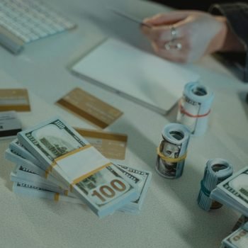Close-up of dollar bills and credit cards on a desk, symbolizing financial transactions.