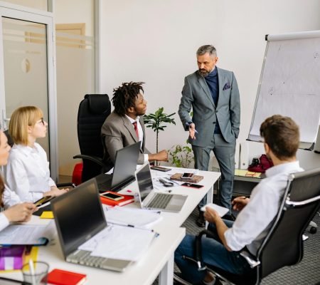 Corporate team in a modern office, engaged in a discussion with diverse colleagues.